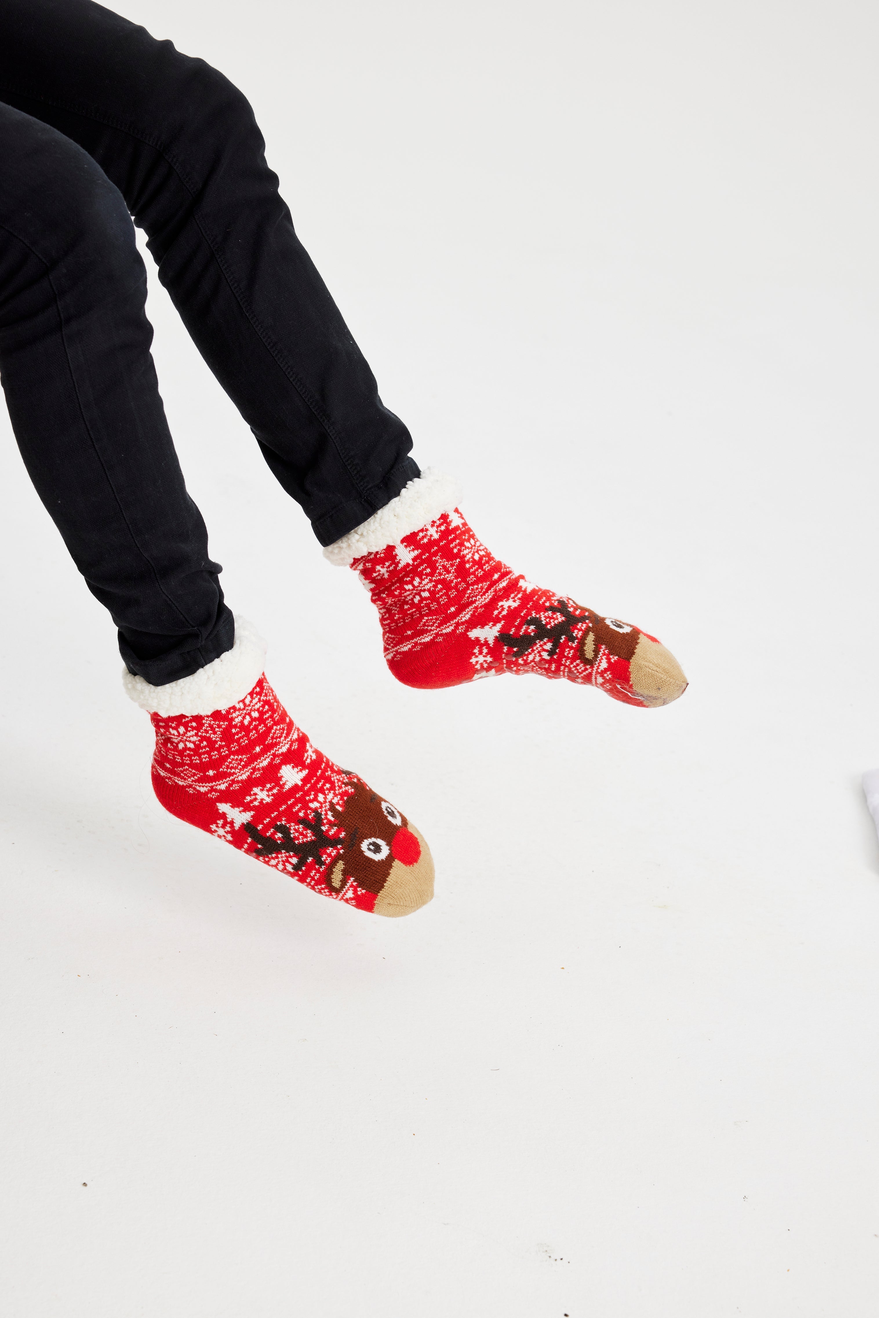 Et par røde julesokker med julemønster og rensdyr på.